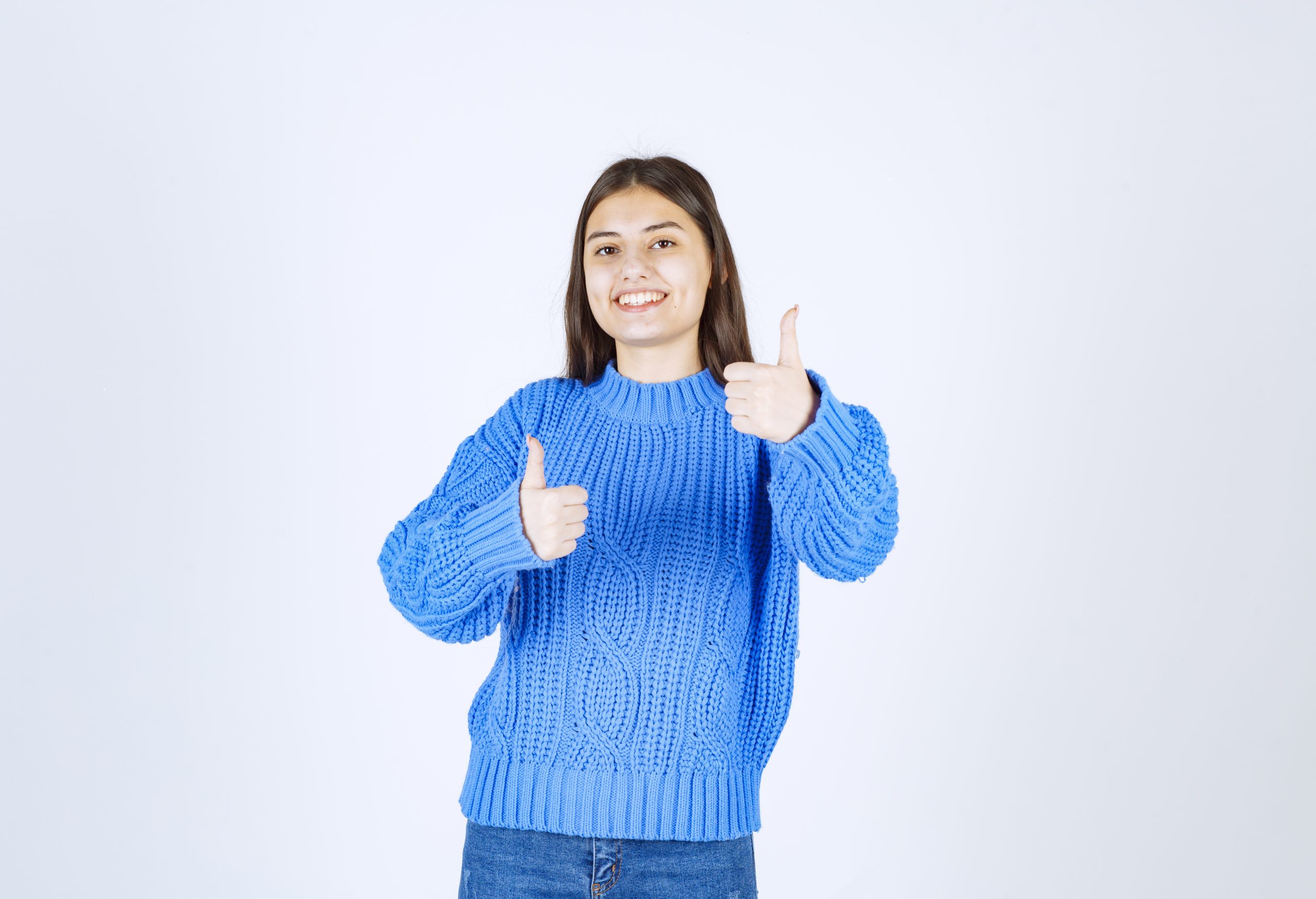 Shot of cute girl standing and giving thumbs up on white background. High quality photo
